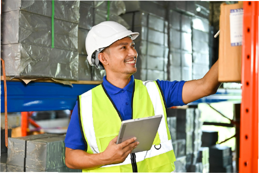 Warehouse worker using a tablet beside inventory racks in a fulfillment center